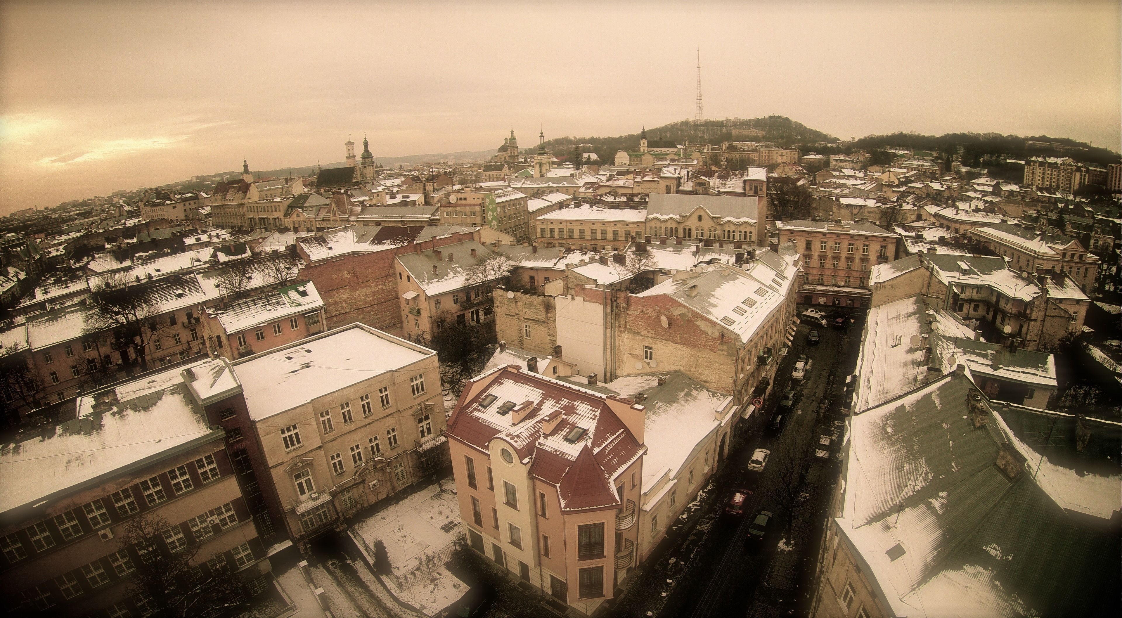 An aerial view of a historic city with snow-covered buildings and a river.