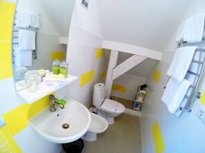 A compact bathroom with a sink, toilet, and towel rack. - A&A Apartments (Lviv)