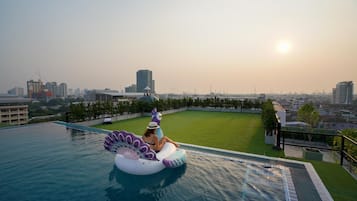 Relax by the serene rooftop pool with a stunning city view.