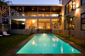 A modern two-story house with a swimming pool, outdoor seating, and a covered patio area. - The Hub Boutique Hotel (Gqeberha (Port Elizabeth))