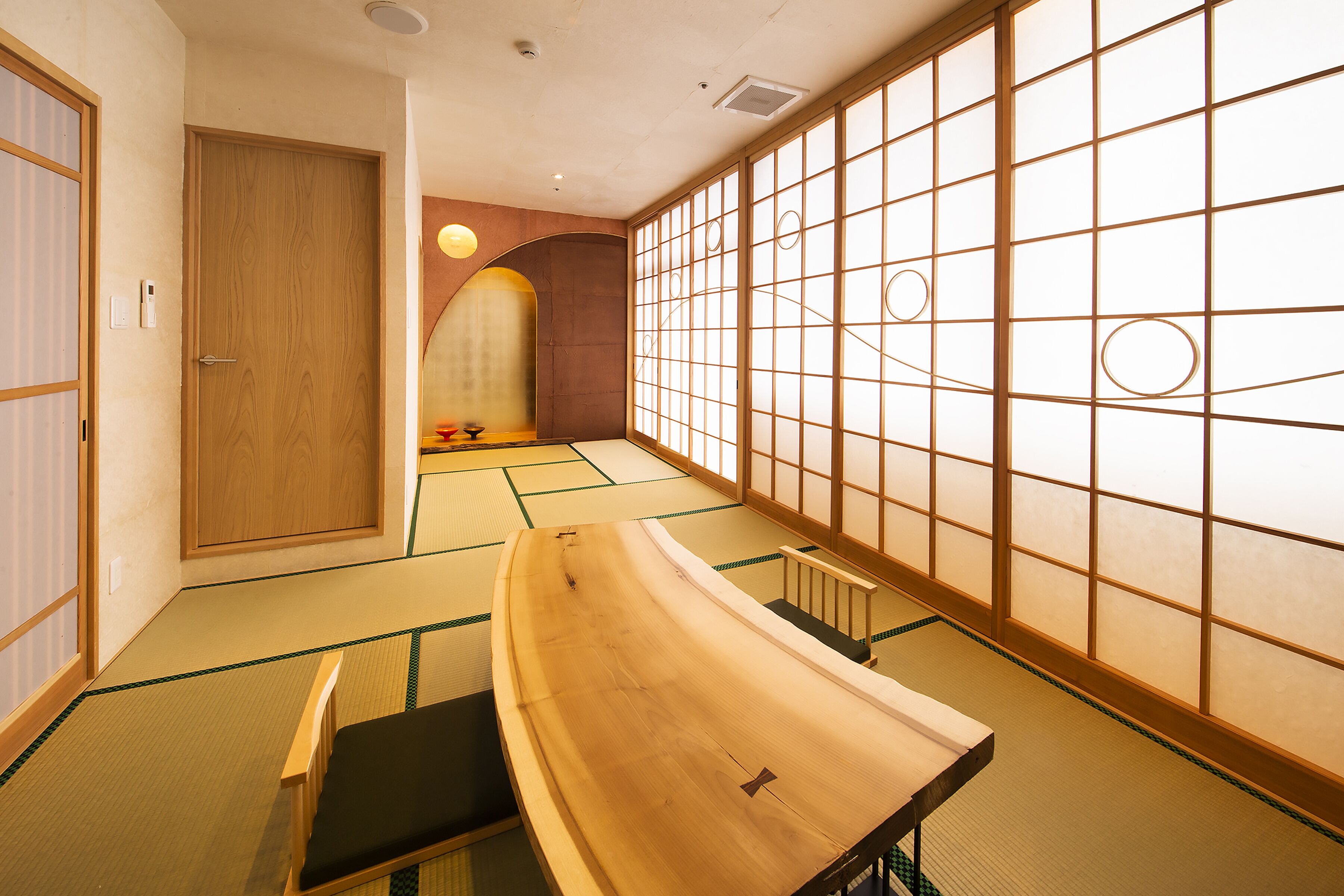 A traditional Japanese room with tatami flooring, a low wooden table, and shoji screens.