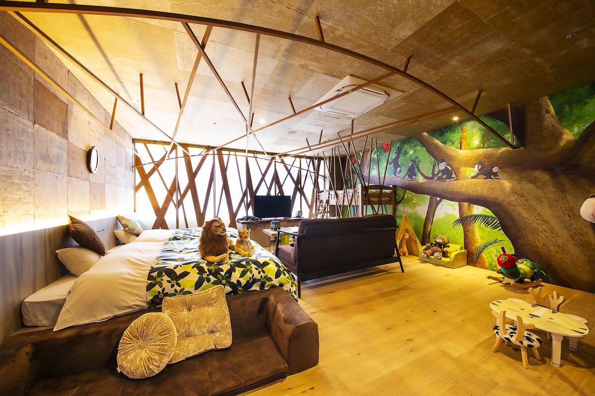 Ein Zimmer mit einem Bett, einem Schlafsofa, einem kleinen Tisch und einem Fernseher.