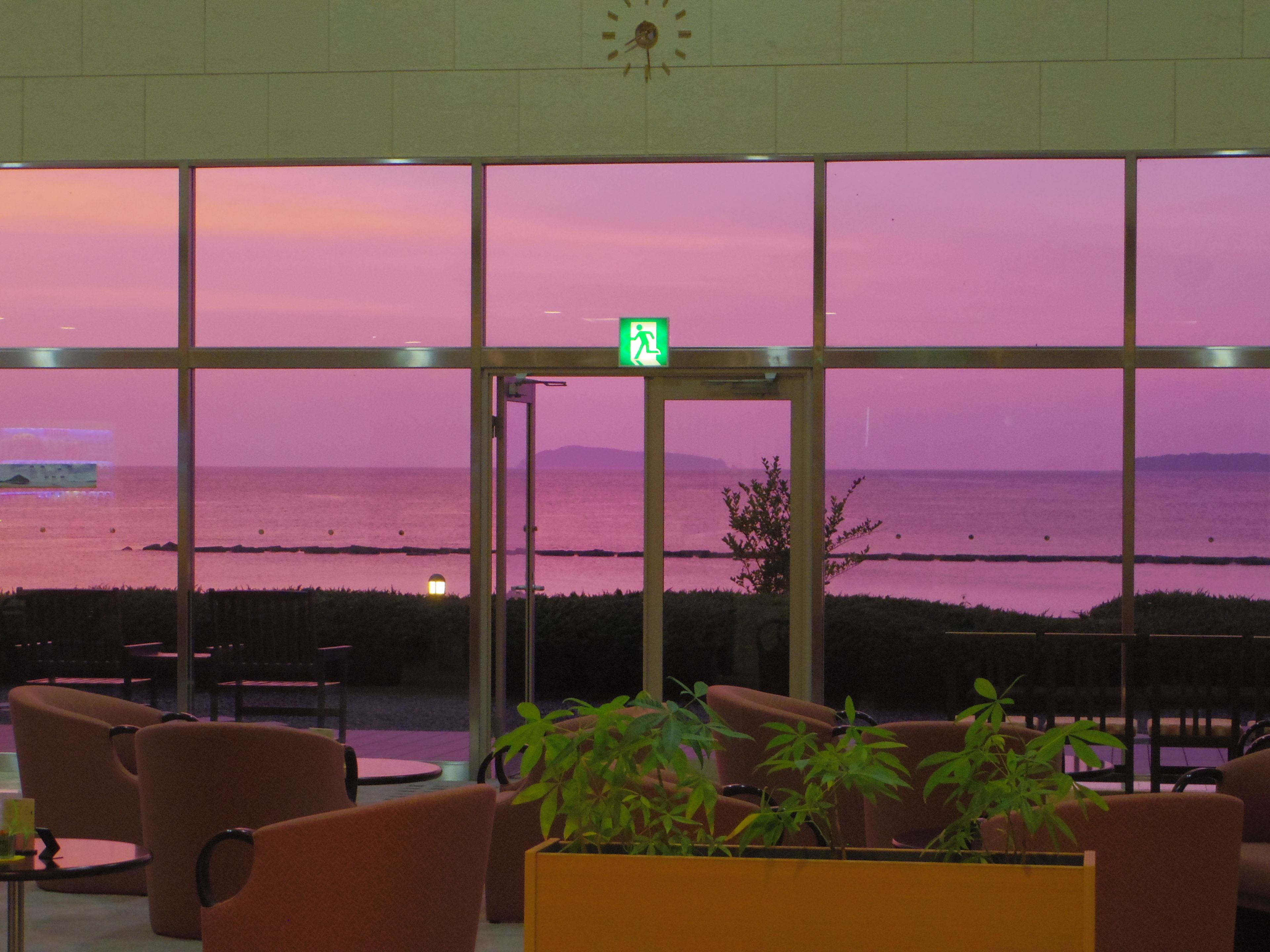 Un área de estar con vistas al mar al atardecer.