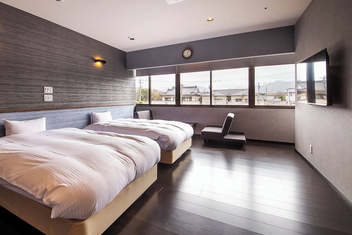 Ein modernes Hotelzimmer mit einem großen Bett, einer Sitzecke und Blick auf die Stadt.