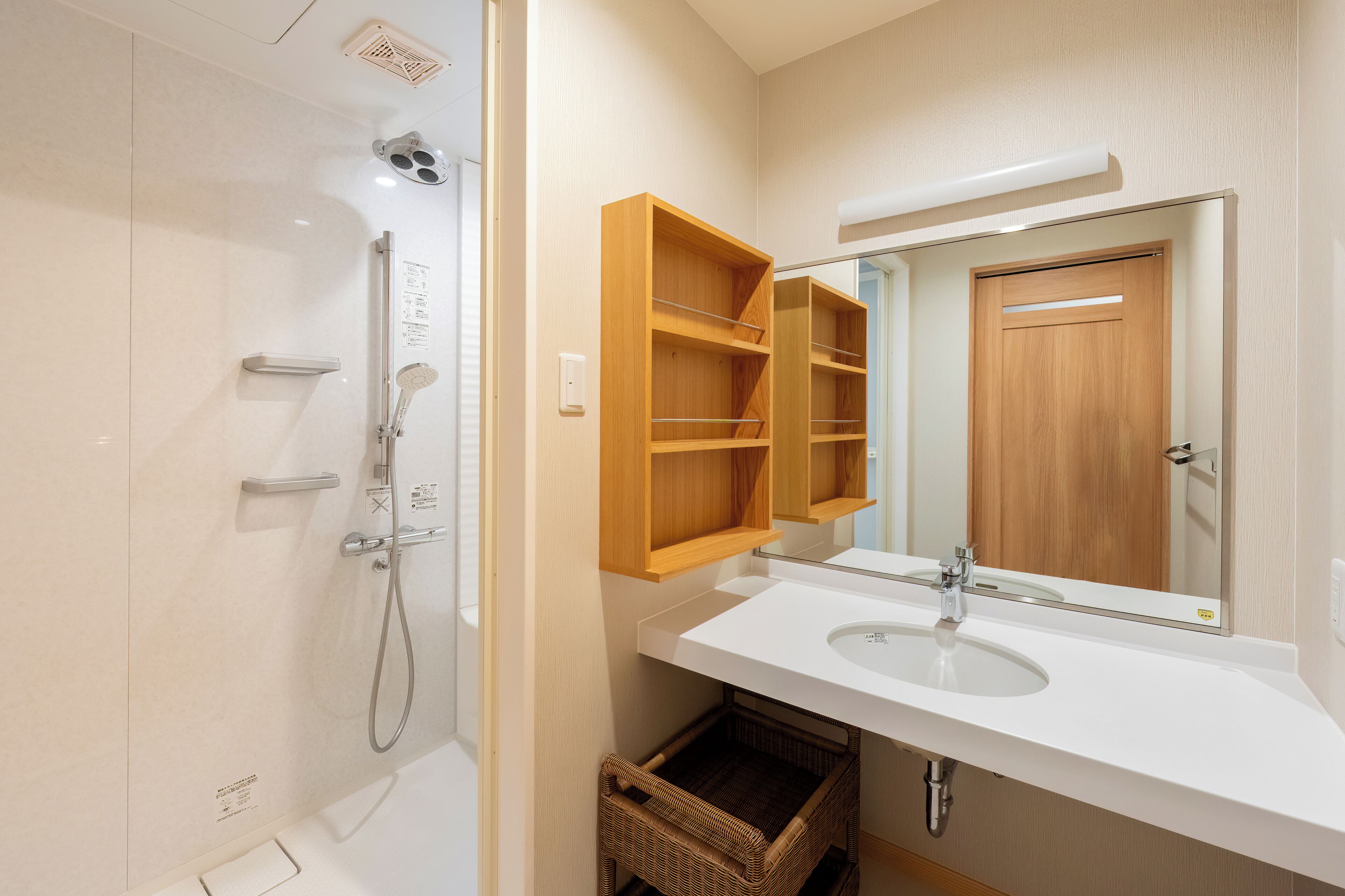A bathroom with a white sink, a wooden medicine cabinet, and a shower.