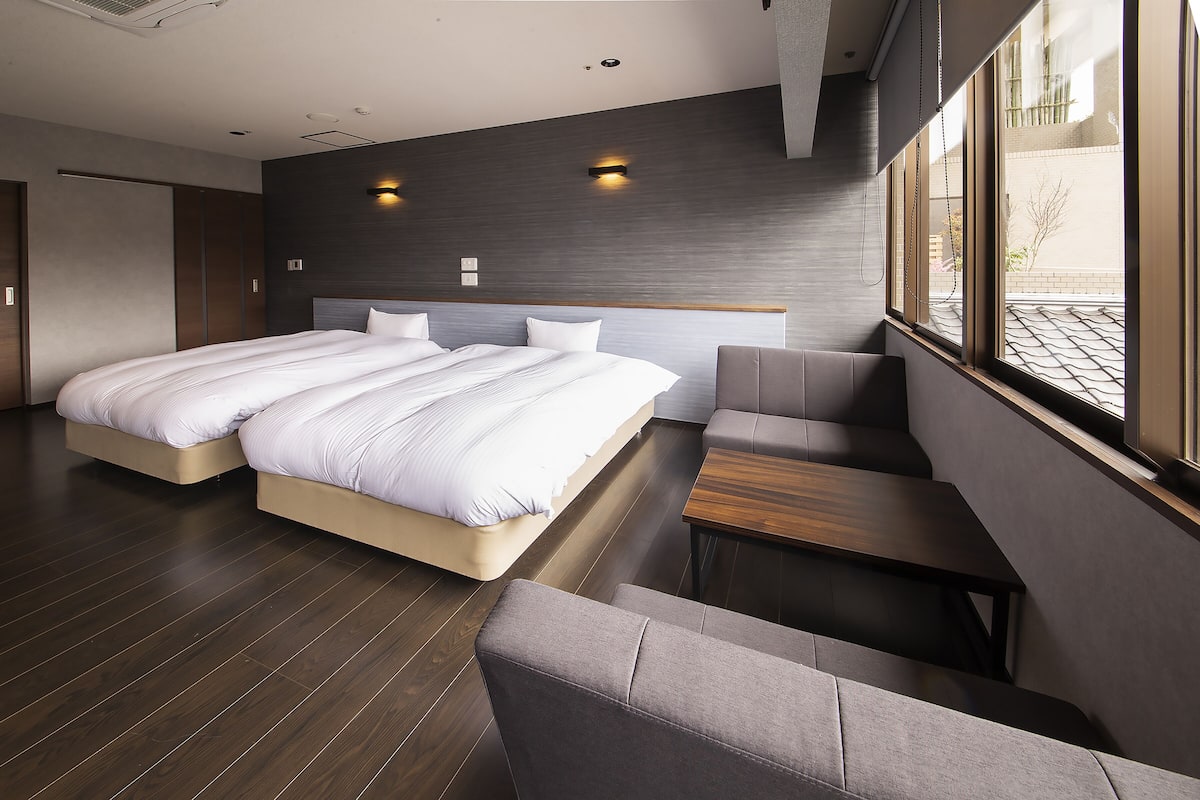 Ein modernes Hotelzimmer mit einem großen Bett, einer Sitzecke und Blick ins Freie.