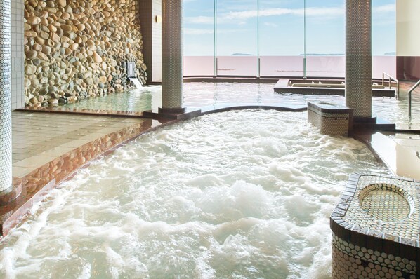 A hot tub area with a stone wall and a view of the sea. - Resort Hotel Mihagi (Hagi)