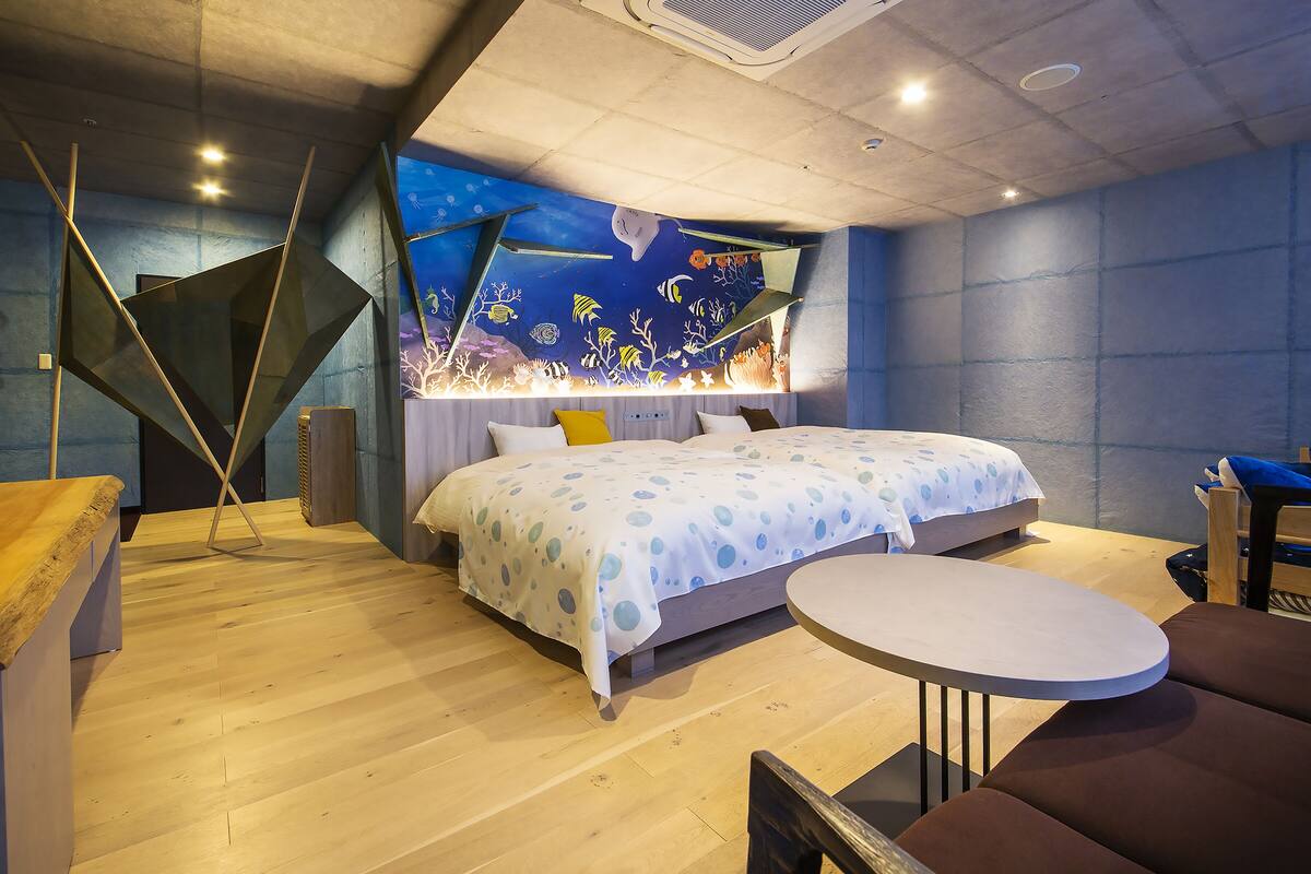 Ein modernes Schlafzimmer mit einem Bett, einem runden Tisch und einem einzigartigen Wandgemälde an der Decke.