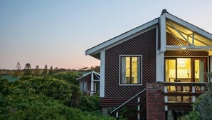 A modern house with a balcony, surrounded by lush greenery. - Pine Lodge Resort (Gqeberha (Port Elizabeth))