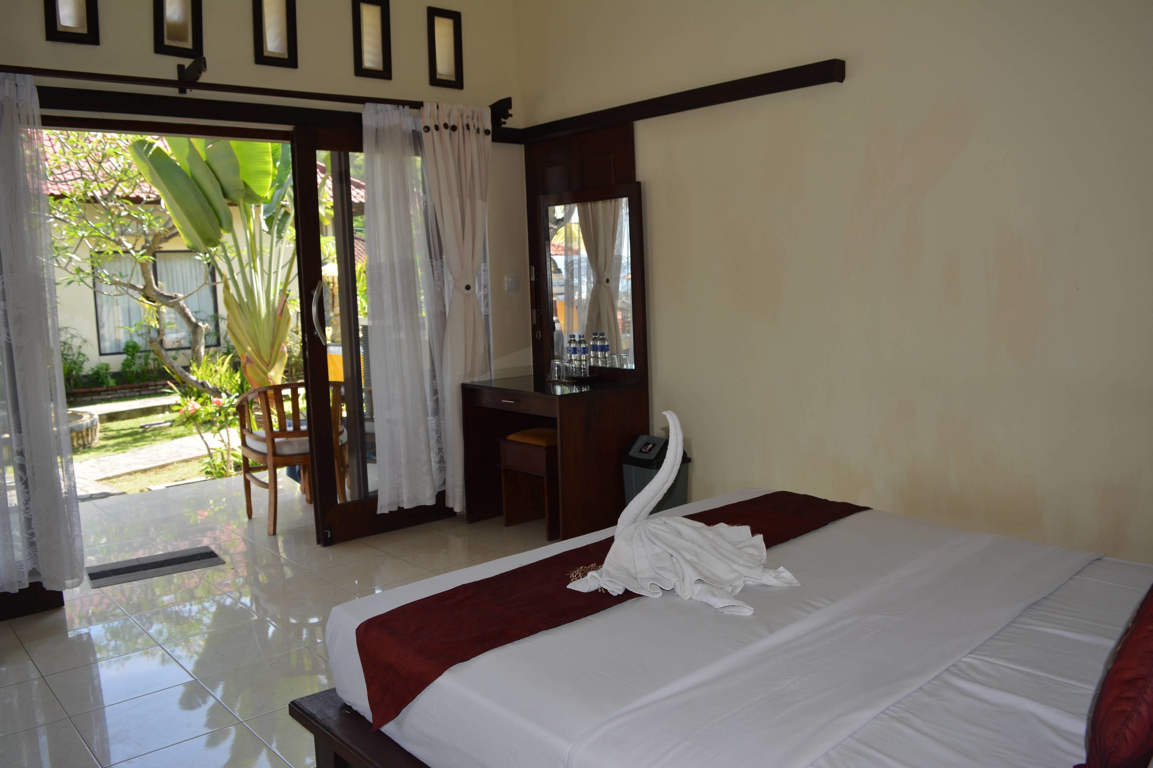 Una habitación de hotel con una cama, un escritorio y una silla.