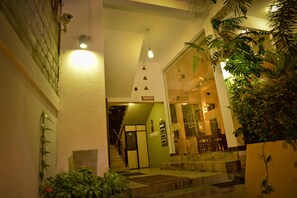 A hotel lobby with a staircase, a reception desk, and a sign indicating a restaurant. - Peacock Heritage Anuradhapura (Anuradhapura)