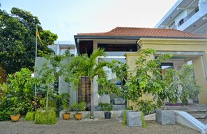 A modern house with a tiled roof, surrounded by potted plants and a well-maintained garden. - Peacock Heritage Anuradhapura (Anuradhapura)