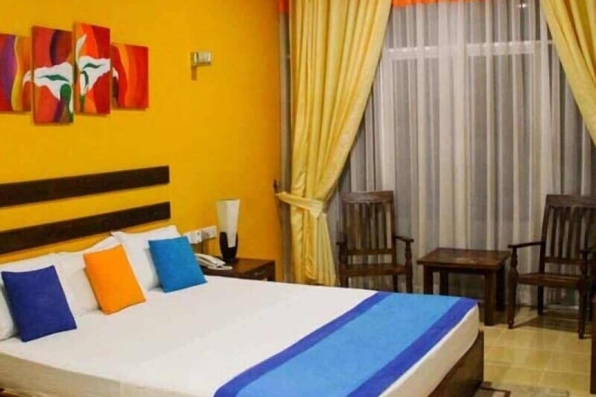 A hotel room with a bed, a nightstand, a chair, and a table.