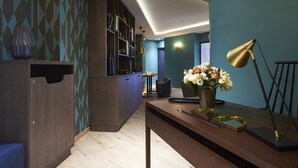 Un interior moderno con un mueble de madera oscura, un escritorio con un florero y una lámpara.