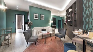 Una sala de estar moderna con un sofá, dos sillones, una mesa de centro y una estantería.