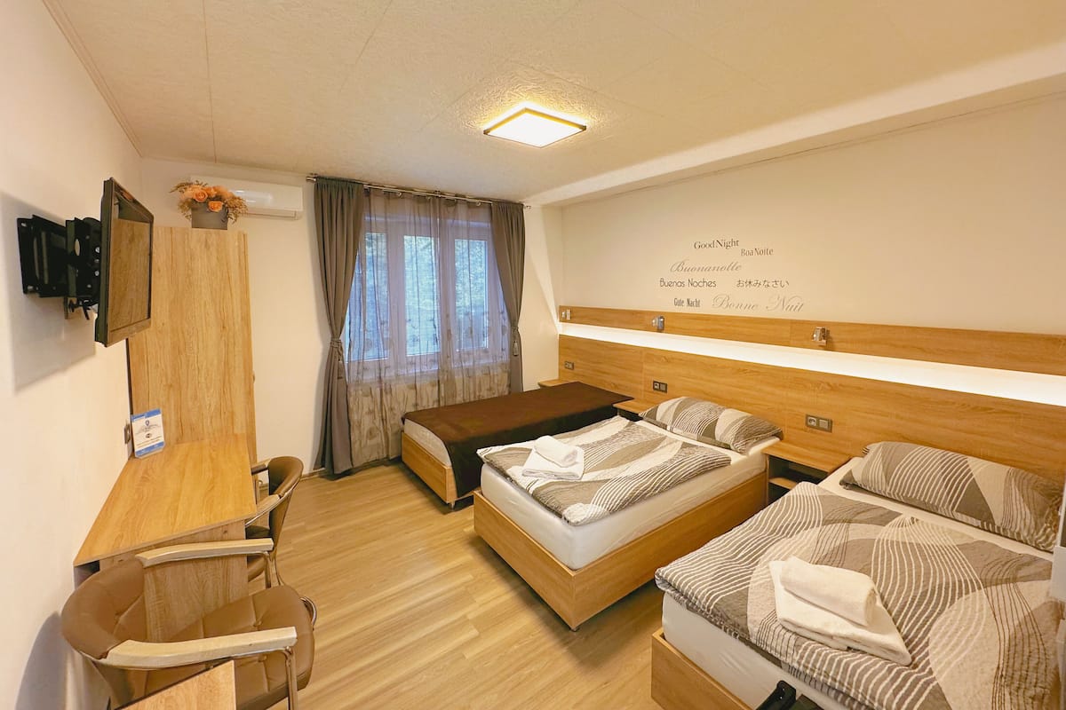 Une chambre d’hôtel avec un lit, un bureau, une chaise et une petite table.