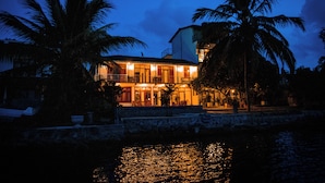 A waterfront property with a large building featuring multiple balconies and a pool area. - Riverside Inn Fuji (Bentota)