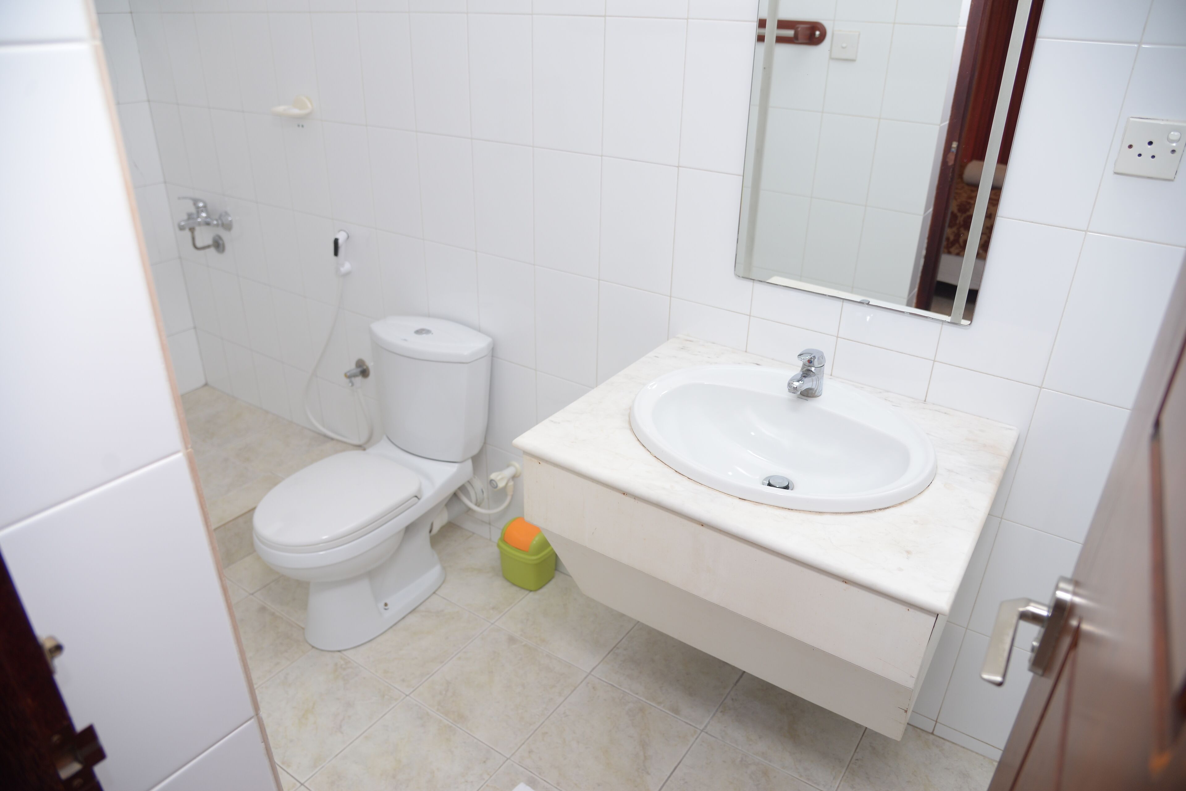 Un baño pequeño con inodoro, lavamanos y espejo.