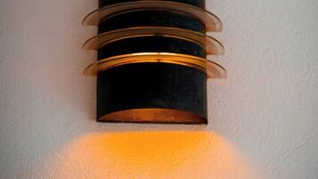 Een wandlamp met een cilindrische vorm en horizontale metalen banden.