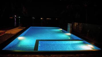 Una piscina rectangular con superficie de azulejos y un muro perimetral.