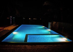 A rectangular swimming pool with a tiled surface and a surrounding wall.