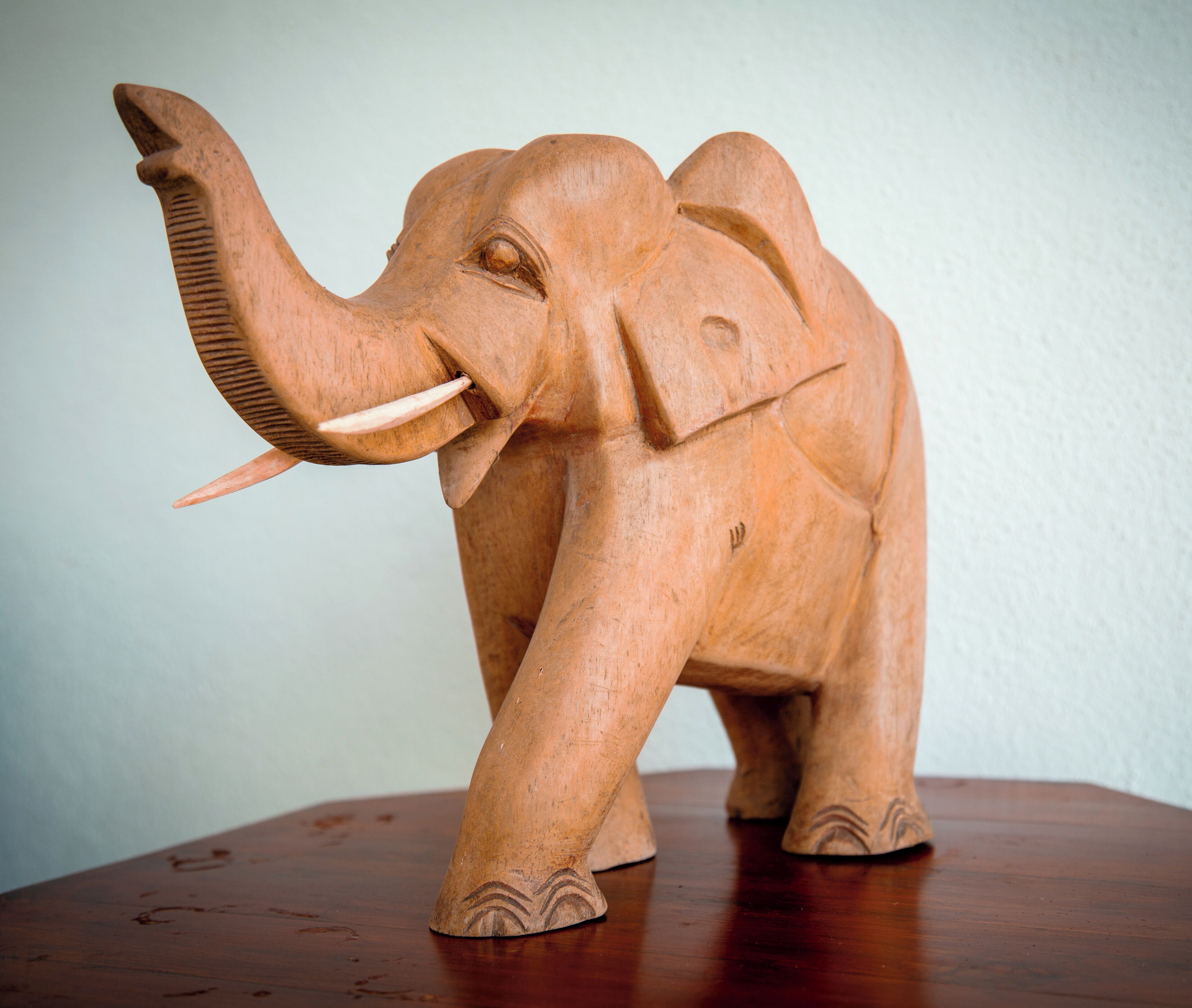 A wooden elephant sculpture on a wooden table.