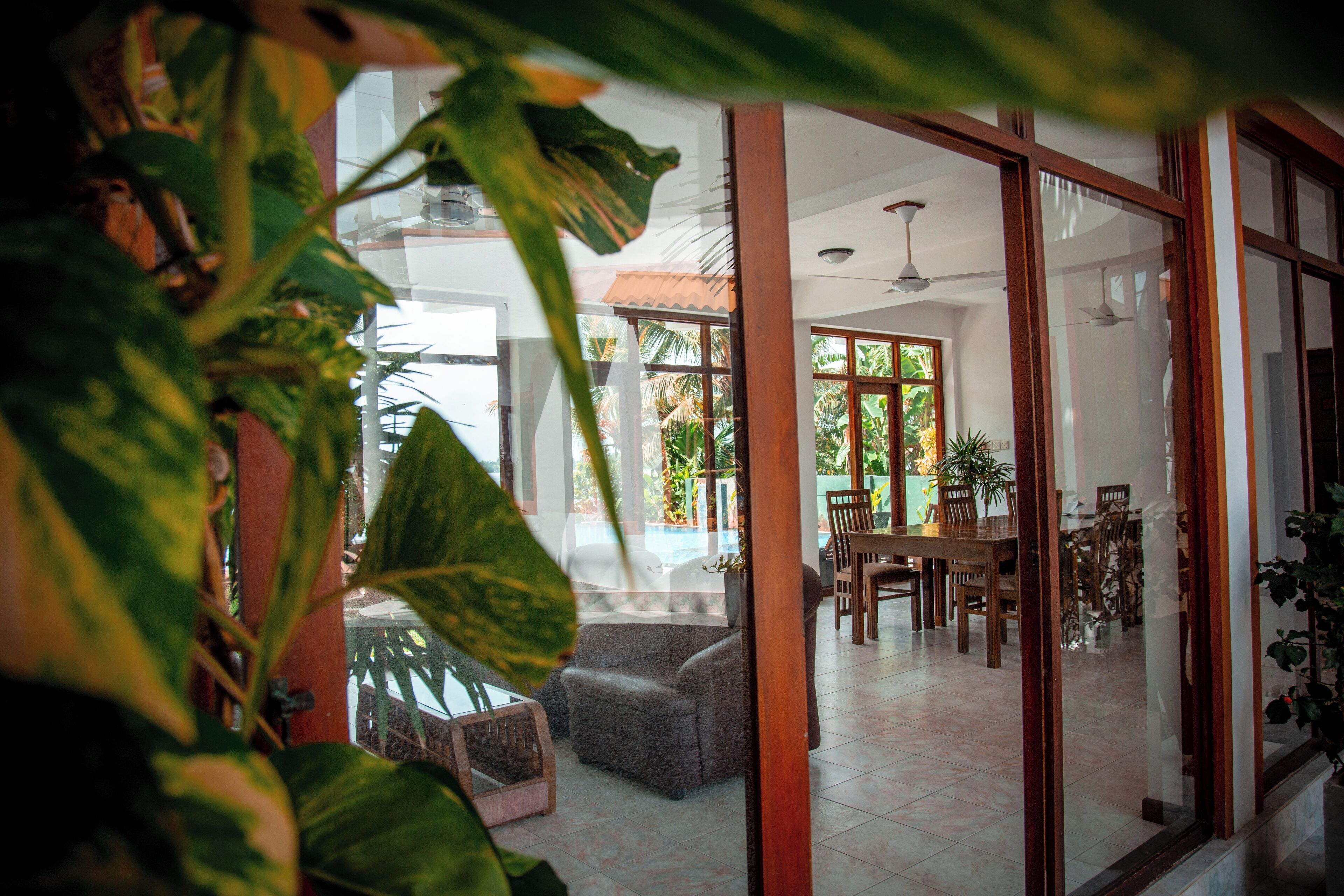 Un salón amplio con una mesa de comedor y sillas, un sofá, y un ventanal que ofrece vistas al exterior.