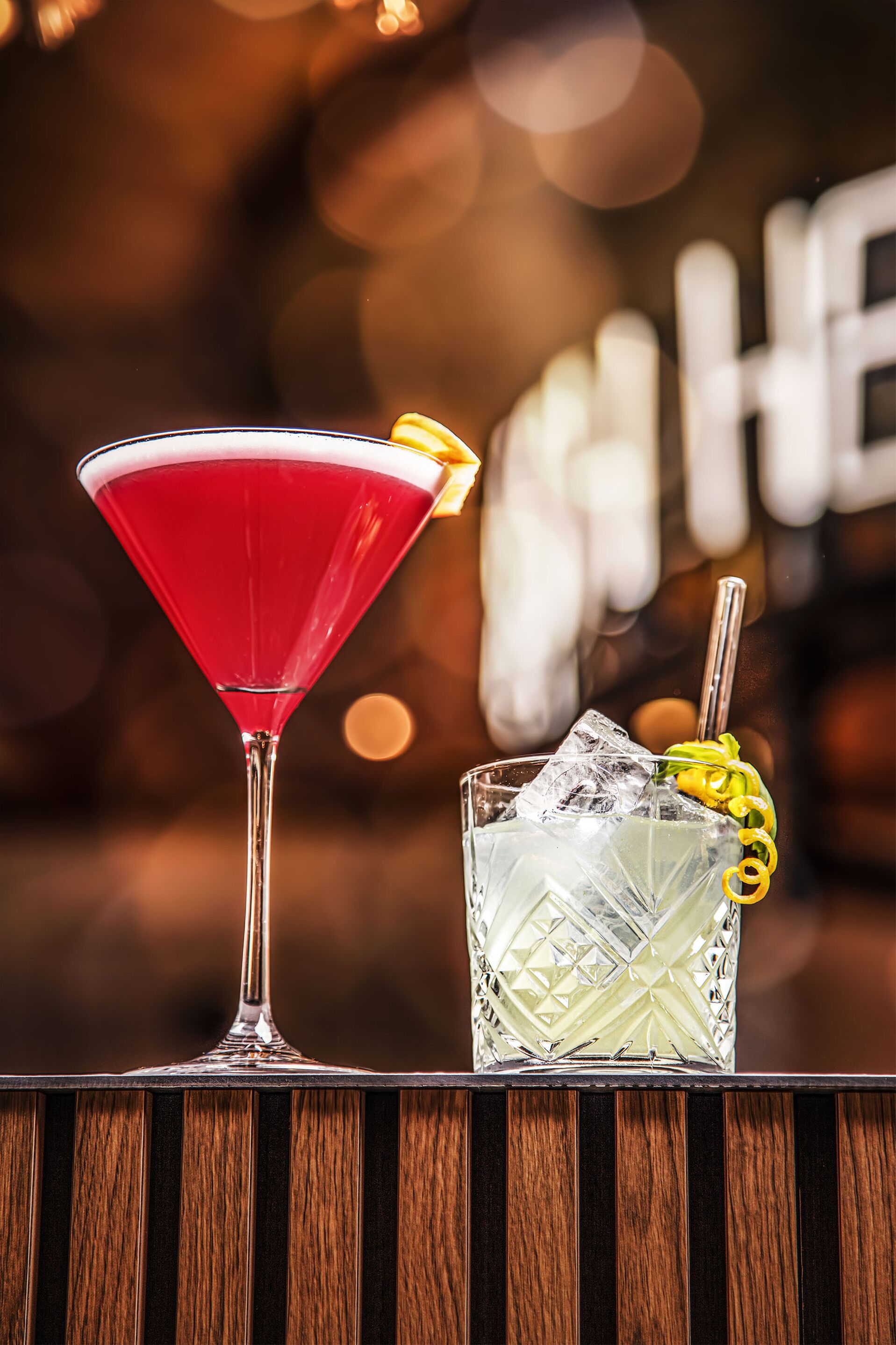 Two drinks on a bar counter with a blurred background.
