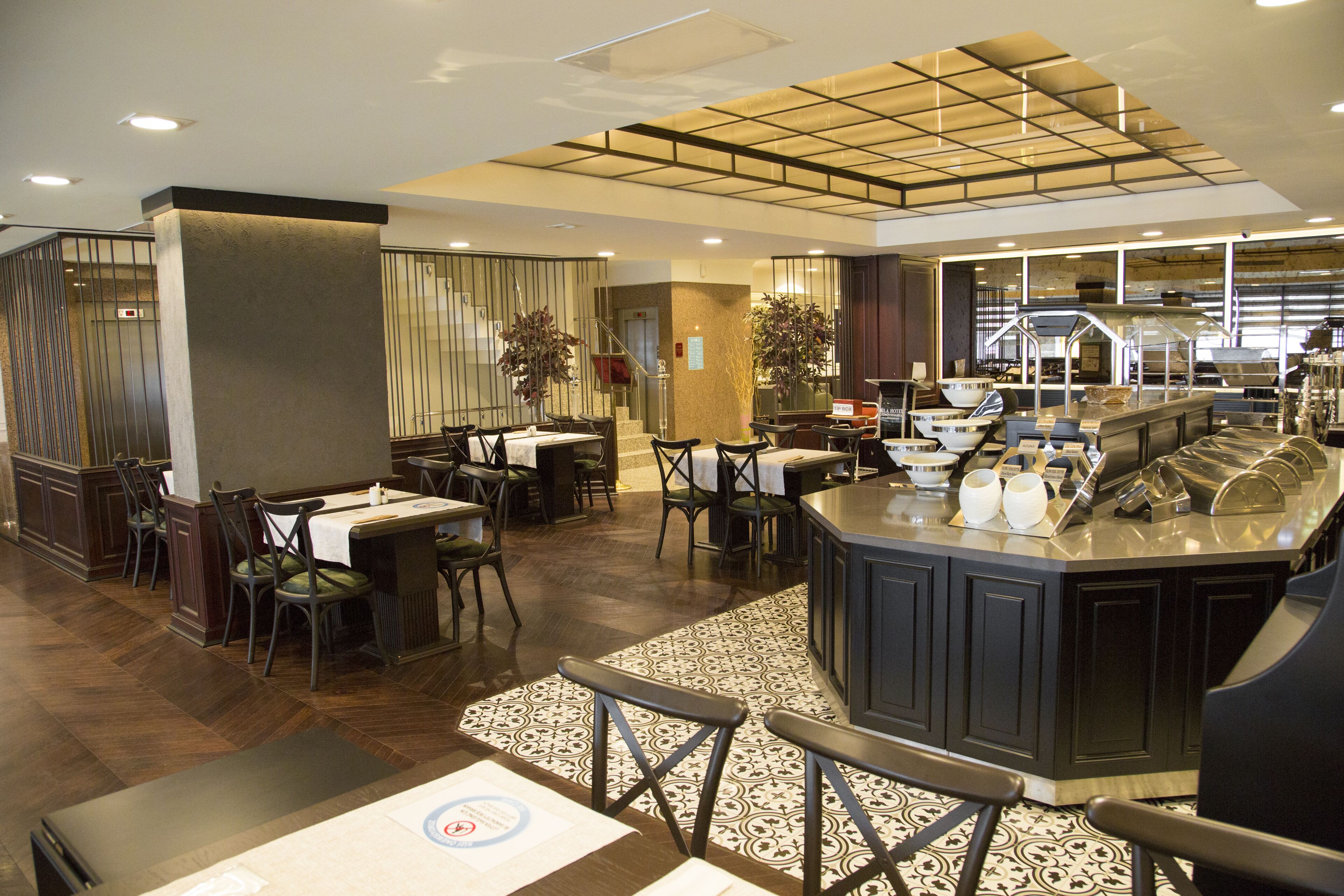Un restaurant doté d’un îlot central, de plusieurs espaces de restauration et d’un sol à motifs.