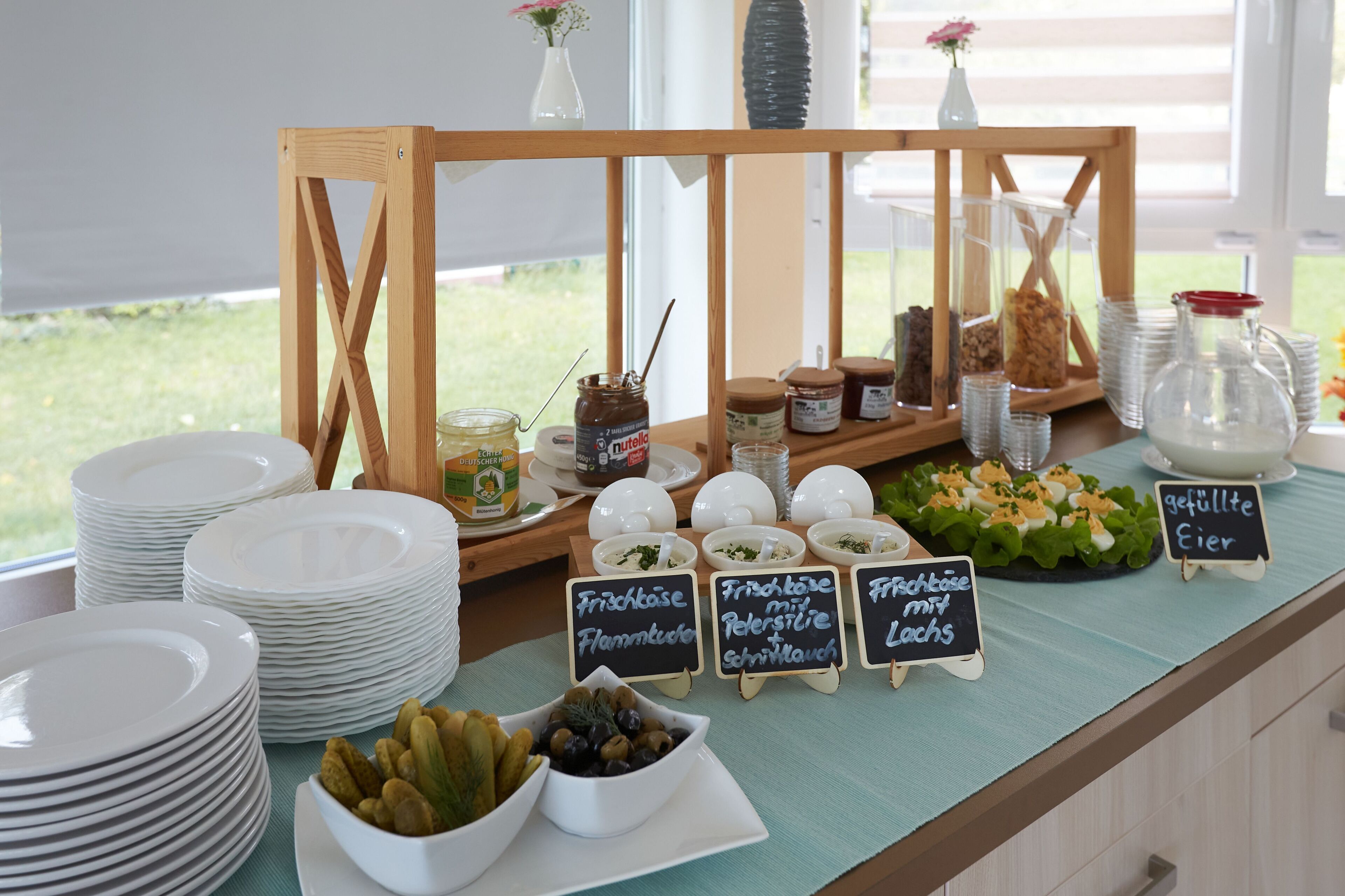 A buffet setup with various food items and labels in a dining area.