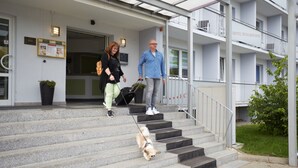 A hotel entrance with a covered staircase, a sign for the hotel, and a small garden area. - Hotel Weimarer Berg (Apolda)