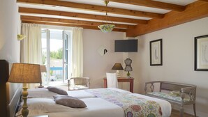Una habitación con dos camas, televisión, una silla y una mesa.