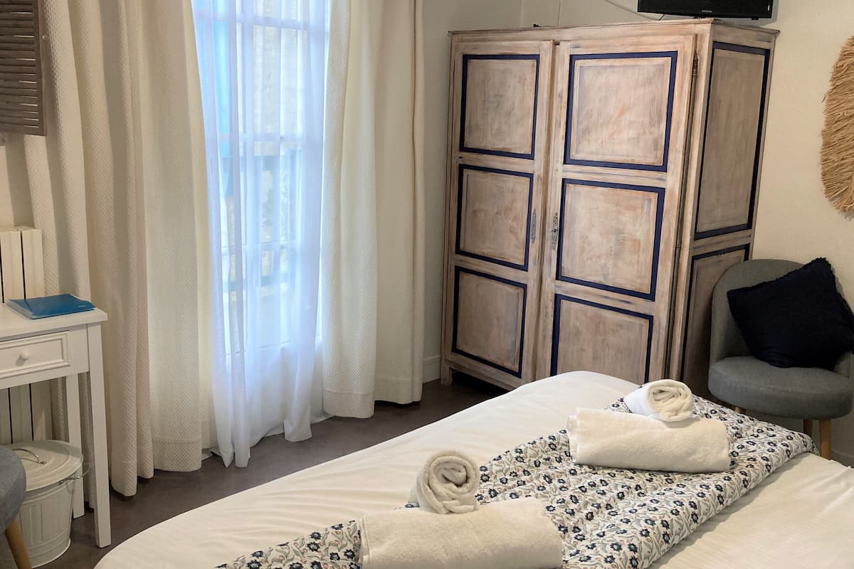 Un dormitorio con cama, escritorio, armario y silla.