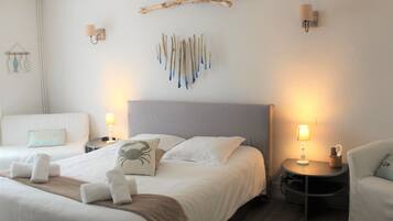 A hotel room with a large bed, two bedside tables with lamps, a chair, and a wall-mounted art piece.