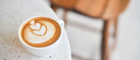 A cup of coffee with latte art on a white table.