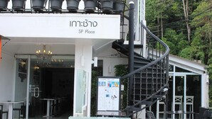 A modern building with a sign reading "SP Place" and a staircase leading to an upper level. - SP Place Hotel (Ko Chang)