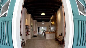 A spacious kitchen with a central island, a dining area with chairs, and a bar area with a counter. - The Rommanee Boutique Guesthouse (Phuket)