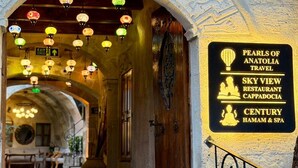 An entrance with a sign for 'Pearls of Anatolia Travel' and 'Sky View Restaurant Cappadocia'. - Century Cave Hotel (Nevsehir)