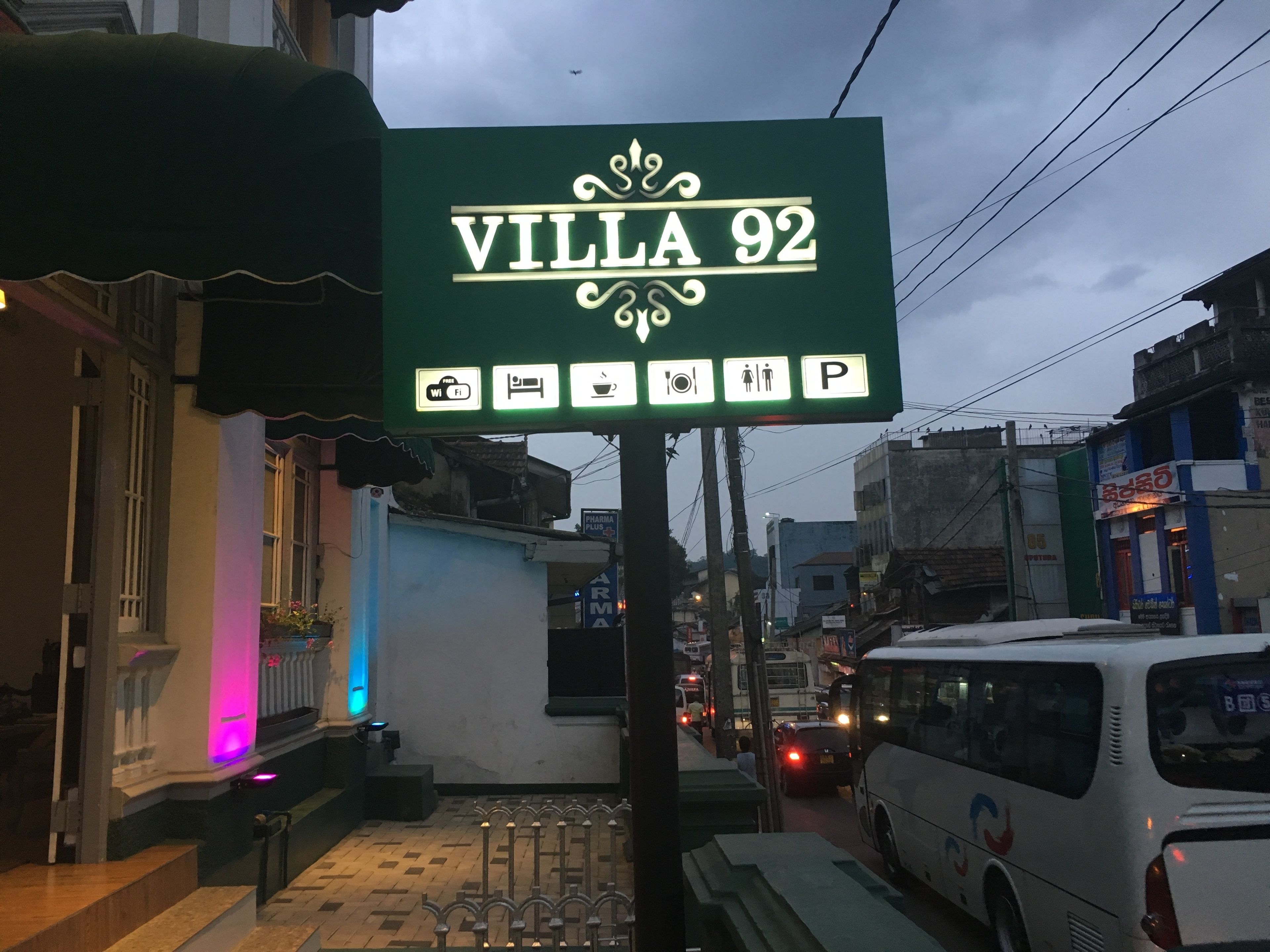 A sign for Villa 92 with icons indicating WiFi, a bed, a toilet, a camera, and a parking space.