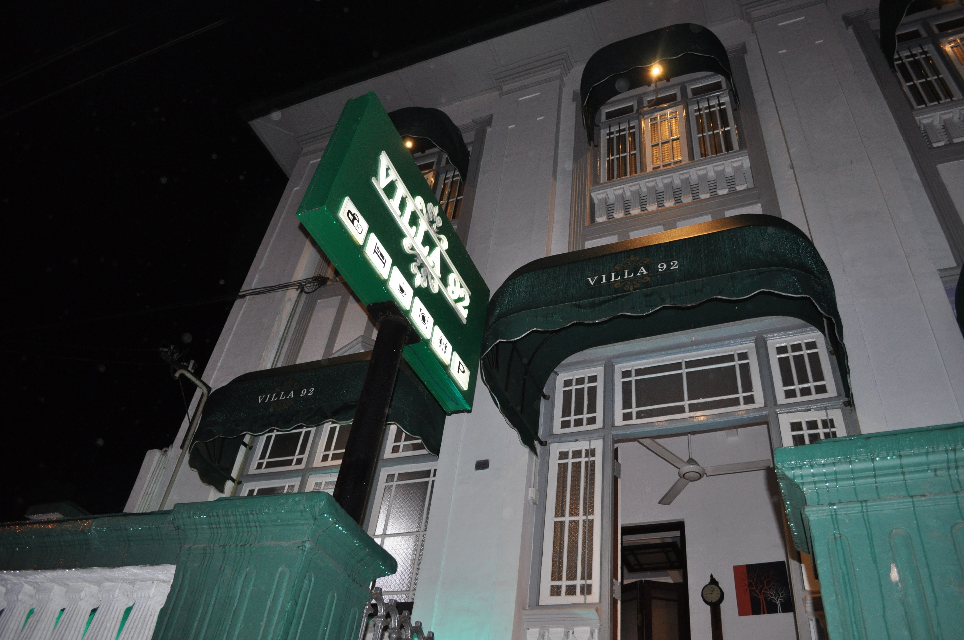 A building with a sign reading "Villa 92" and a green awning.