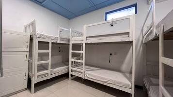 A room with bunk beds, a window with a view, and a door with a handle.