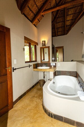 A bathroom with a bathtub, a sink, and a window.