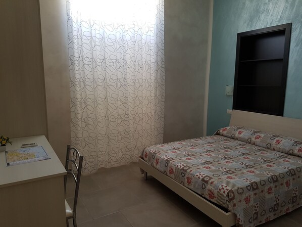 A small, neatly arranged bedroom with a single bed, a desk, and a chair. - B&B Le Torri Aragonesi (Naples)