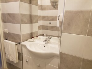 A bathroom with a white sink, mirror, and towel rack.
