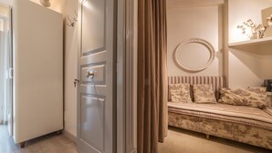 Ein Zimmer mit einem Bett, einem Kleiderschrank und einem Spiegel.