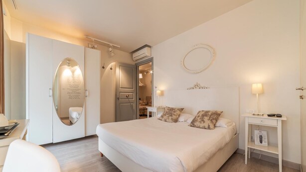 Ein modernes Schlafzimmer mit einem großen Bett, einem Schreibtisch, einem Stuhl und einem Kleiderschrank.