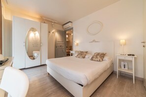 A modern bedroom with a large bed, a desk, a chair, and a wardrobe. - Nina Casetta de Trastevere (Rome)