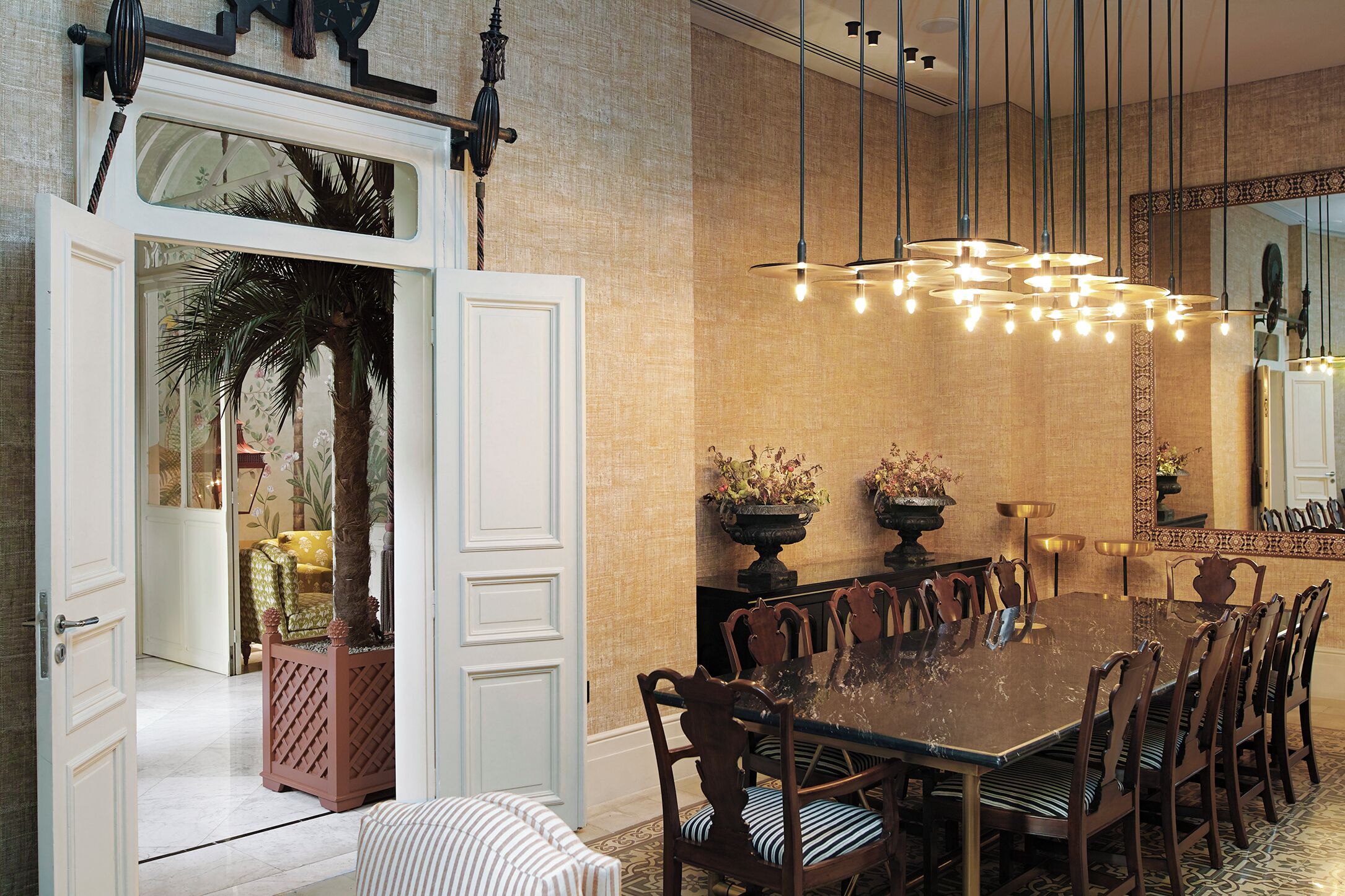 A dining room with a large table, chairs, and a chandelier.