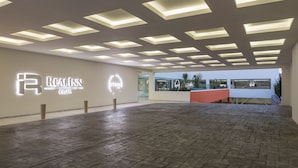 Un vaste espace intérieur doté d’un plafond au design moderne, d’un comptoir d’accueil et offrant une vue dégagée sur l’extérieur grâce à de grandes fenêtres.