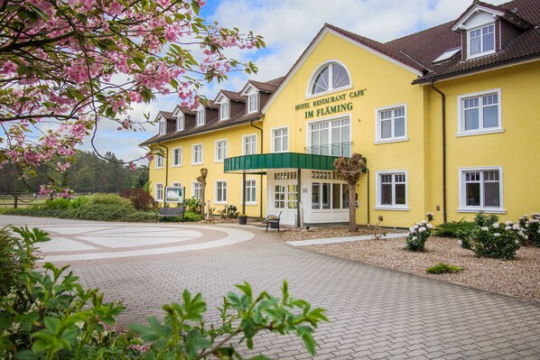 A yellow building with a green awning, labeled "Hotel Restaurant Cafe Im Flaming." - Ferien Hotel Fläming (Rabenstein/Fläming)